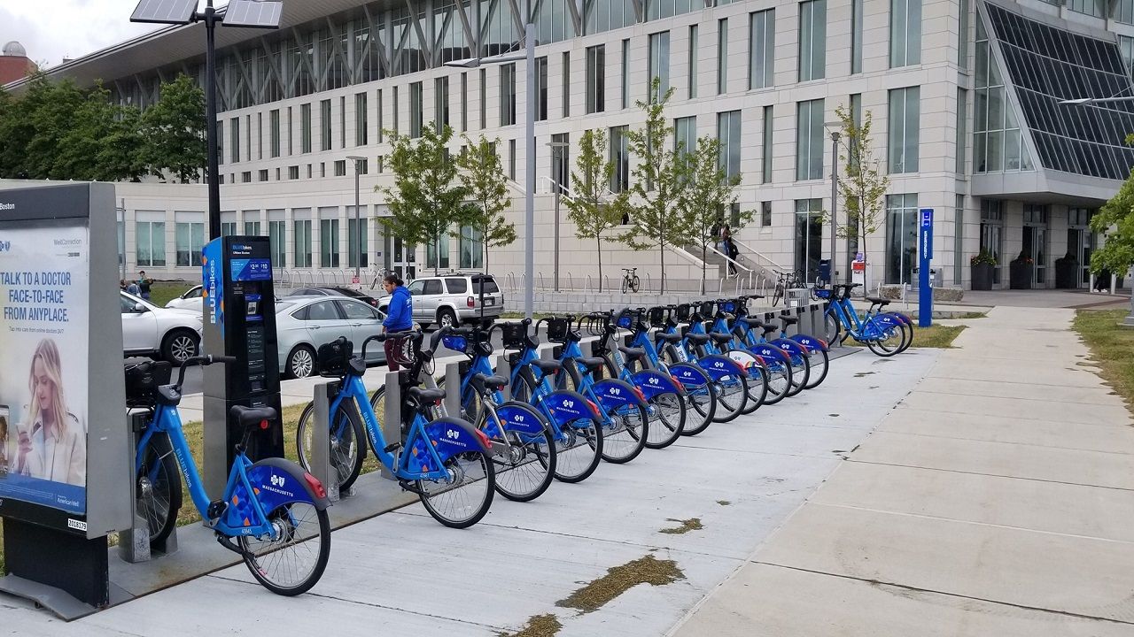 Một trạm Blue Bikes phía trước Đại học Massachusetts Boston. Blue Bikes là hệ thống chia sẻ xe đạp, cung cấp hơn 1.800 xe đạp tại 200 trạm trên khắp Boston, Brookline, Cambridge và Somerville